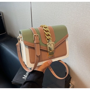 Detail of color-block flap bag with military green panels and gold chunky chain buckle