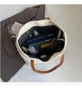 Vue de dessus de l'intérieur du grand sac fourre-tout blanc avec poches et doublure grise