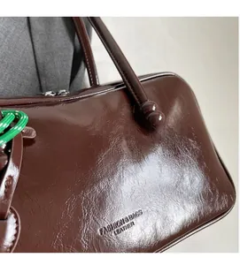 Vue macro du cuir marron foncé du sac bowling avec logo gaufré et texte de mode