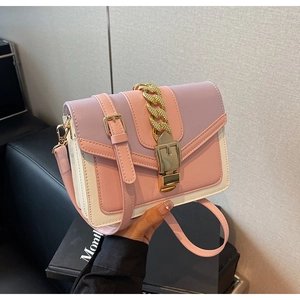 Detail of the pink and purple color-block handbag with gold chain and metal buckle closure