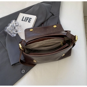 Internal view of brown vintage messenger bag showing multiple compartments and zipper
