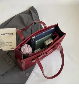 Macro view showing large capacity and internal storage of the burgundy tote bag