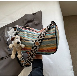 Detailed close-up of rainbow woven pillow bag with ethnic strap and plush dog charm