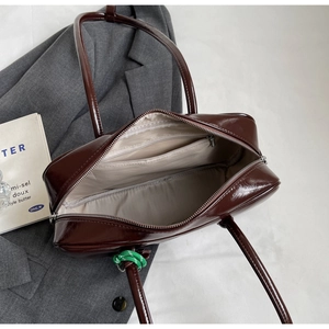 Détails intérieurs d'un sac bowling vintage avec doublure beige clair et poches zippées