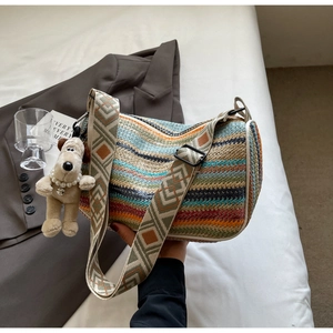 Close-up of rainbow woven bag featuring a colorful striped pattern and wide shoulder strap