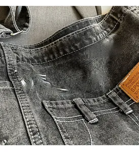 Detailansicht aus Denim mit THE MONSTERS Bestickung und braunem Lederpatch-Detail