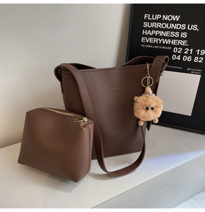 Detail of dark brown litchi pattern bucket bag set with pouch and plush charm