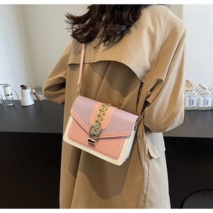 Side view of a contrast color crossbody bag with a gold chain and metal buckle