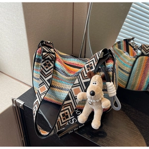 Detailed shot of rainbow woven bag with ethnic pattern strap and plush dog charm