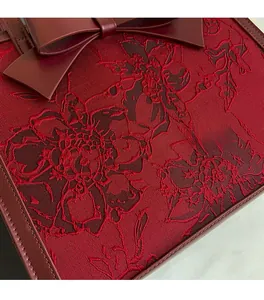 Close-up of luxury bridal handbag with floral jacquard fabric and large leather bow