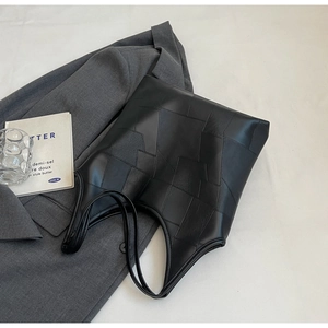Detailed top view of black patchwork leather tote bag with stylish geometric texture