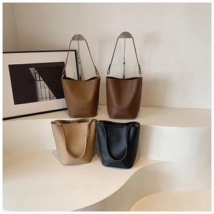 Detailed arrangement of textured leather bucket bags in multiple modern earthy colors
