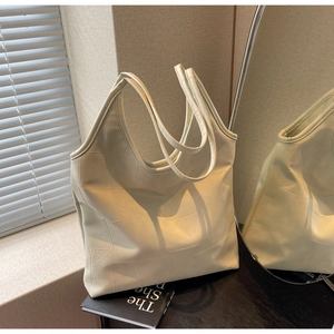 Detailed close-up of cream white tote bag with geometric stitching on black table