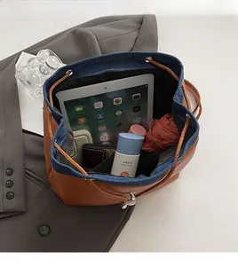 Spacious bucket backpack interior with drawstring closure showing storage for tablet and umbrella