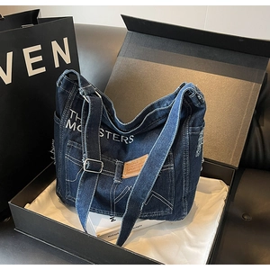 Nahaufnahme der Jeans-Umhängetasche mit weißer Stickerei und Kontrastnähten