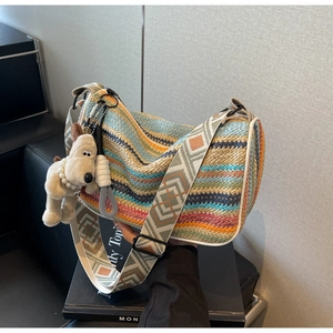 Close-up of rainbow woven pillow bag with colorful wave patterns and jacquard strap