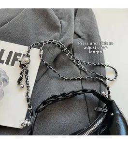 Detail of black leather bag showing adjustable silver chain with sliding metal ball