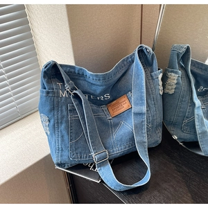 Detailansicht der Jeans-Einkaufstasche mit braunem Lederpatch und weißer Stickerei