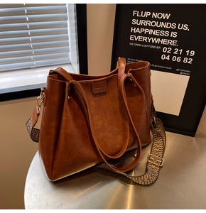 Détail du sac cabas en similicuir marron avec une bandoulière à motif géométrique