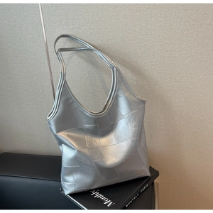 Detail of silver geometric patchwork tote bag with metallic textured surface