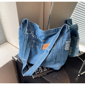 Detailansicht der blauen Denim-Tragetasche mit THE MONSTERS Print und Schultergurt