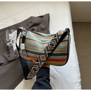 Detail of bohemian rainbow woven shoulder bag with wide geometric strap and fringe charm