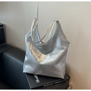 Detailed macro view of silver geometric patchwork texture on large tote bag