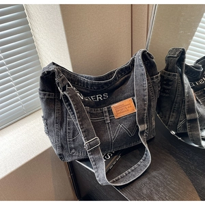 Detail der dunkelgrauen Denim-Umhängetasche mit Vintage-Taschen und verstellbarem Gurt