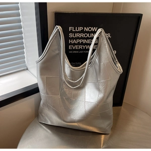 Detail of silver patchwork leather tote bag with metallic texture and sleek finish