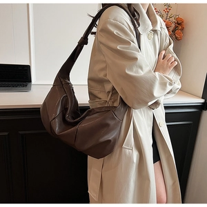 Detail shot of a dark brown soft leather hobo bag with unique knotted strap and pleated design