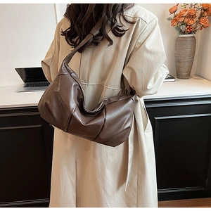 Detail view of the brown slouchy shoulder bag featuring cloud-like pleated PU leather