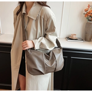 Close-up of taupe soft leather tote bag with pleated design and wide shoulder strap