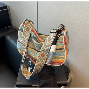 Macro detail of multi-color woven handbag with ethnic geometric wide shoulder strap