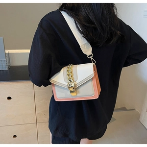 Detailed back view of model wearing a tri-color crossbody bag with a wide woven strap