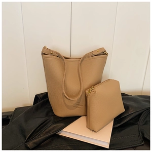 Detail of beige lychee texture bucket bag and matching zipper pouch set with PARIS logo