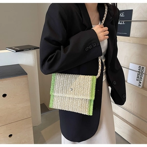 Dettaglio borsa a tracolla in paglia intrecciata verde e beige con tracolla