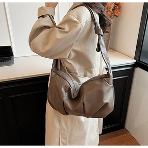 Detail of soft pleated leather shoulder bag in coffee color featuring wide strap