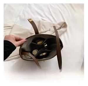 Detailed interior view of a brown suede crossbody bag showing makeup storage capacity