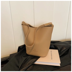 Detail of camel lychee leather bucket bag with gold hardware and PARIS logo branding