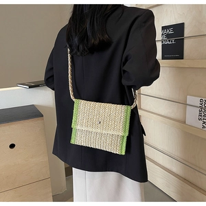 Borsa a tracolla a busta in paglia con design color-block verde su una modella