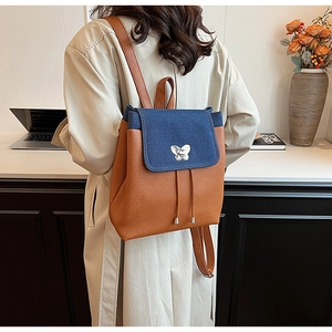 Detail of retro vintage leather and denim backpack with a silver butterfly clasp buckle
