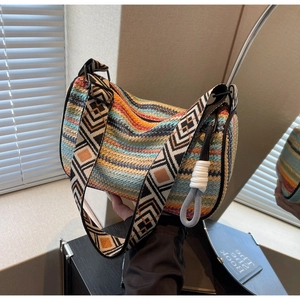 Detail of colorful woven shoulder bag with wide geometric pattern strap and wave texture