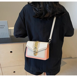 Detail shot of the color-block crossbody bag featuring a golden chain buckle and strap