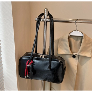 Détail du sac bowling en cuir froissé noir avec fermeture éclair argentée et pendentif
