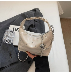 Detailed view of cream beige quilted PU leather handbag with silver studs and chain strap