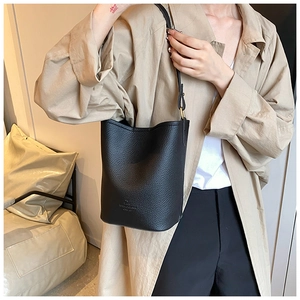 Close-up of a stylish black bucket bag made of premium pebbled leather with brand embossing