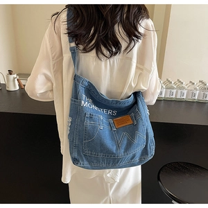 Detailansicht der Denim-Schultertasche mit THE MONSTERS Print und Retro-Taschendesign