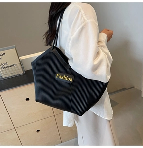 Detail of black pleated tote bag with Fashion label shown in a lifestyle setting