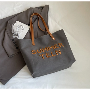 Détail du sac cabas en toile gris foncé avec broderie SUMMER TELN orange vif