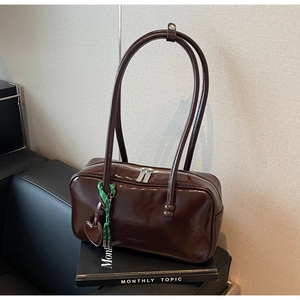 Détails du sac bowling en cuir marron foncé avec fermetures argentées et pendentif cœur